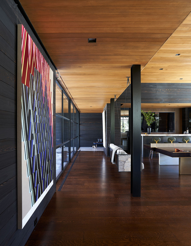 Diseño de recibidores y pasillos modernos grandes con paredes negras, suelo de madera en tonos medios, suelo marrón, madera y madera