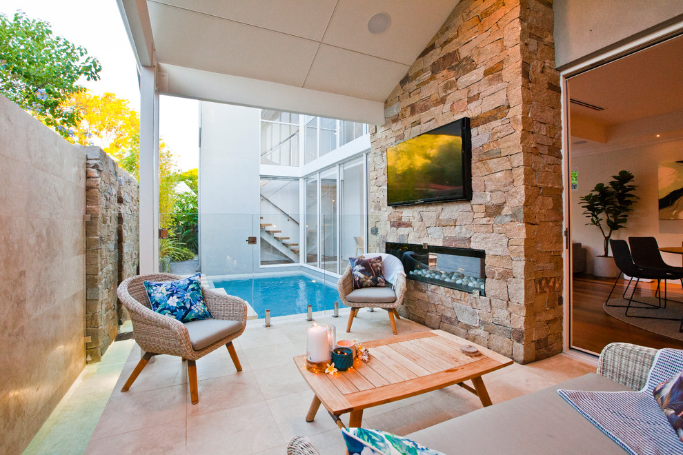 Design ideas for a small beach style backyard patio in Perth with tile and a roof extension.