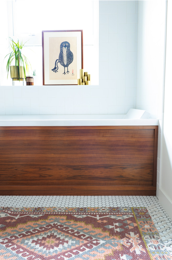 This is an example of a small midcentury 3/4 bathroom in Vancouver with flat-panel cabinets, medium wood cabinets, an alcove tub, a shower/bathtub combo, a two-piece toilet, white tile, ceramic tile, white walls, porcelain floors, a vessel sink, wood benchtops, white floor and a shower curtain.
