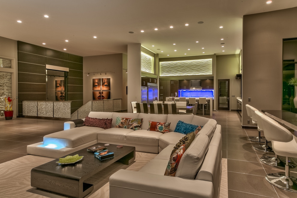 Photo of an expansive contemporary open concept living room in Omaha with grey walls, a wall-mounted tv, a home bar, a ribbon fireplace, a metal fireplace surround and brown floor.