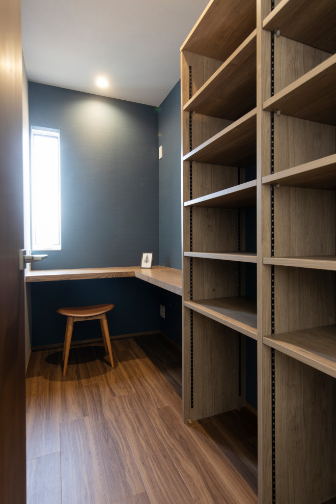 На фото: кабинет с серыми стенами, полом из винила, встроенным рабочим столом, коричневым полом, потолком с обоями и обоями на стенах