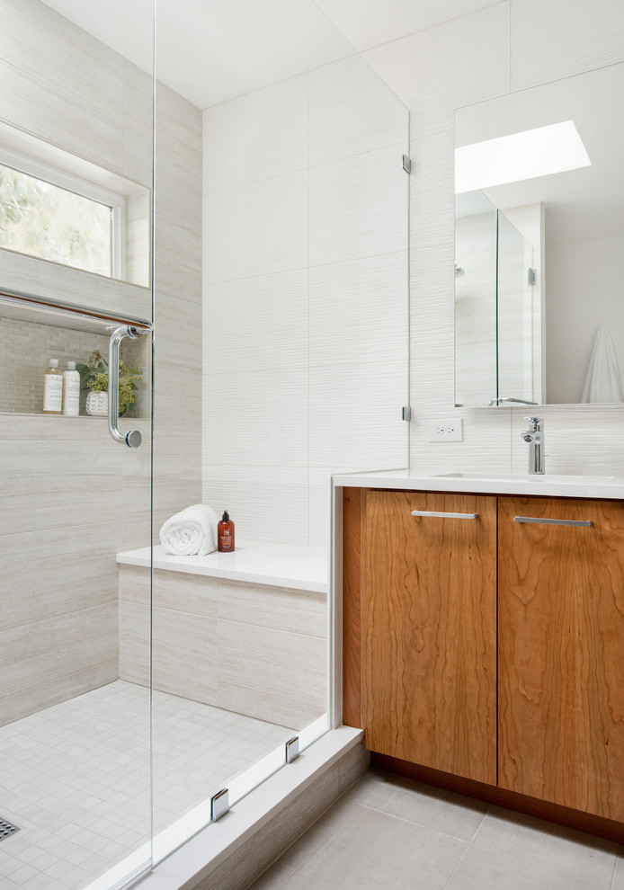 Design ideas for a mid-sized contemporary master bathroom in Portland with flat-panel cabinets, medium wood cabinets, an alcove shower, a one-piece toilet, white tile, ceramic tile, grey walls, porcelain floors, an undermount sink, engineered quartz benchtops, beige floor, a hinged shower door and white benchtops.