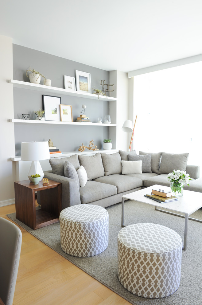 Scandinavian open concept living room in Vancouver with grey walls and light hardwood floors.