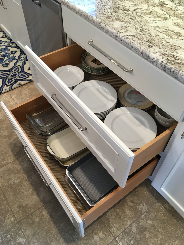 Eat-in kitchen - large transitional l-shaped vinyl floor and beige floor eat-in kitchen idea with a double-bowl sink, recessed-panel cabinets, white cabinets, granite countertops, brown backsplash, ceramic backsplash, stainless steel appliances and an island