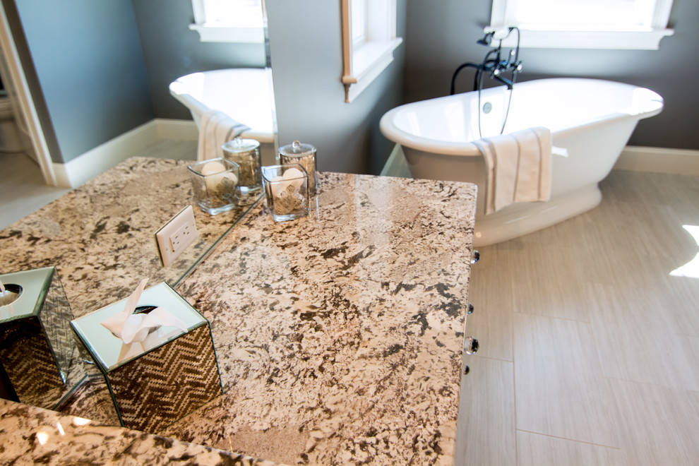 Large transitional master beige tile and ceramic tile ceramic tile freestanding bathtub photo in Providence with an undermount sink, raised-panel cabinets, dark wood cabinets, granite countertops, a two-piece toilet and gray walls