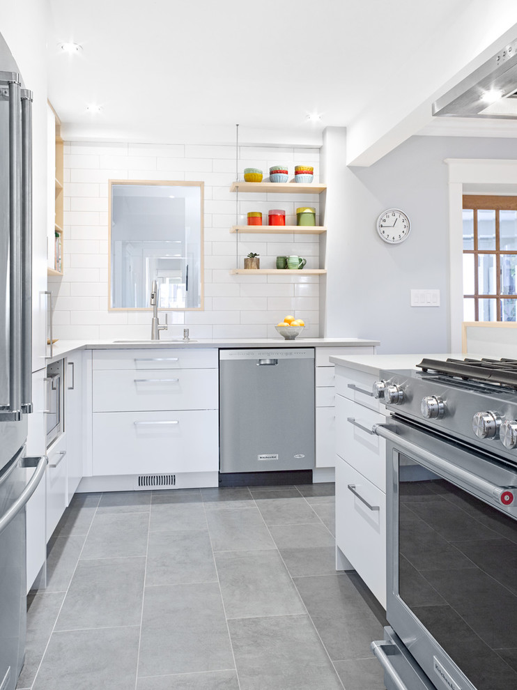 Small scandinavian l-shaped eat-in kitchen in Toronto with an undermount sink, flat-panel cabinets, white cabinets, quartz benchtops, white splashback, subway tile splashback, stainless steel appliances, porcelain floors and a peninsula.