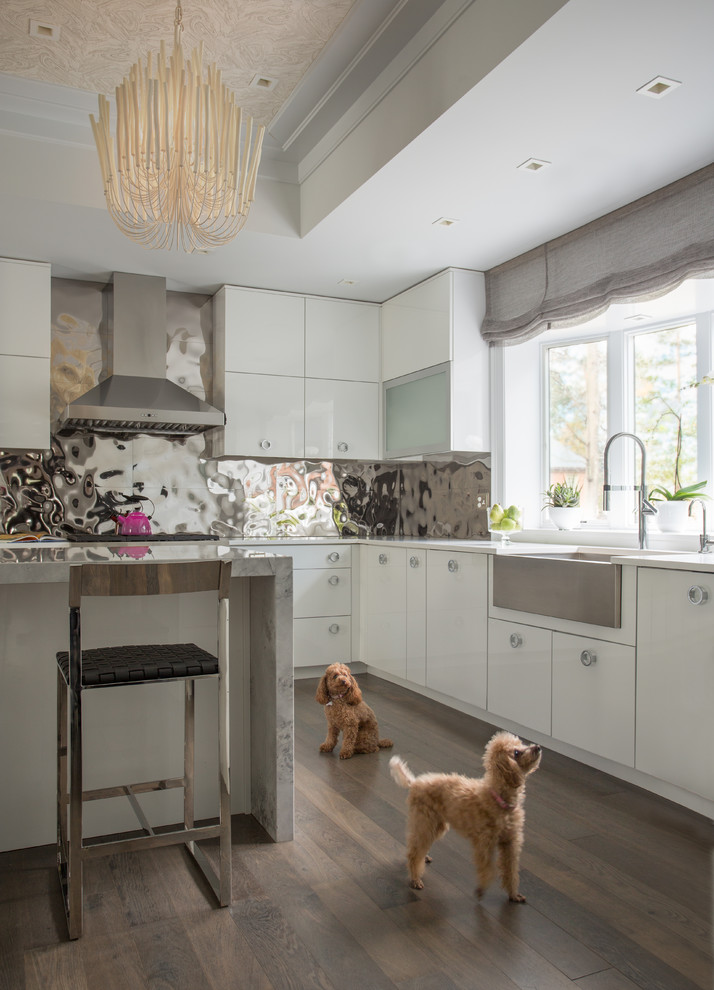Photo of an expansive eclectic u-shaped eat-in kitchen in Boston with a farmhouse sink, flat-panel cabinets, white cabinets, marble benchtops, metallic splashback, metal splashback, stainless steel appliances, medium hardwood floors and with island.