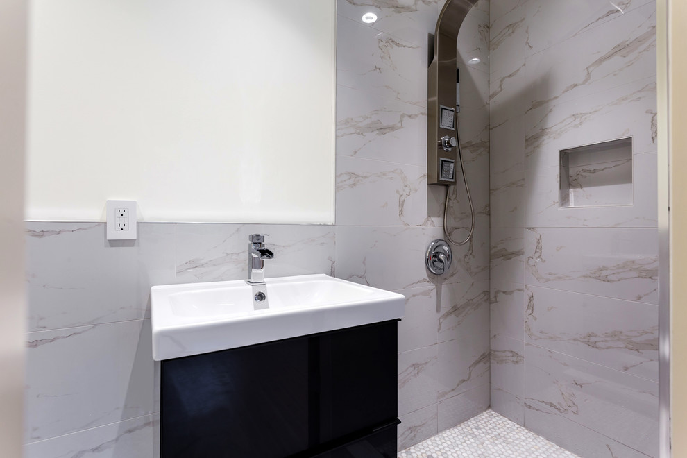 This is an example of a mid-sized contemporary master bathroom in Vancouver with black cabinets, an open shower, a one-piece toilet, gray tile, pebble tile, multi-coloured walls, pebble tile floors, a drop-in sink, marble benchtops and flat-panel cabinets.