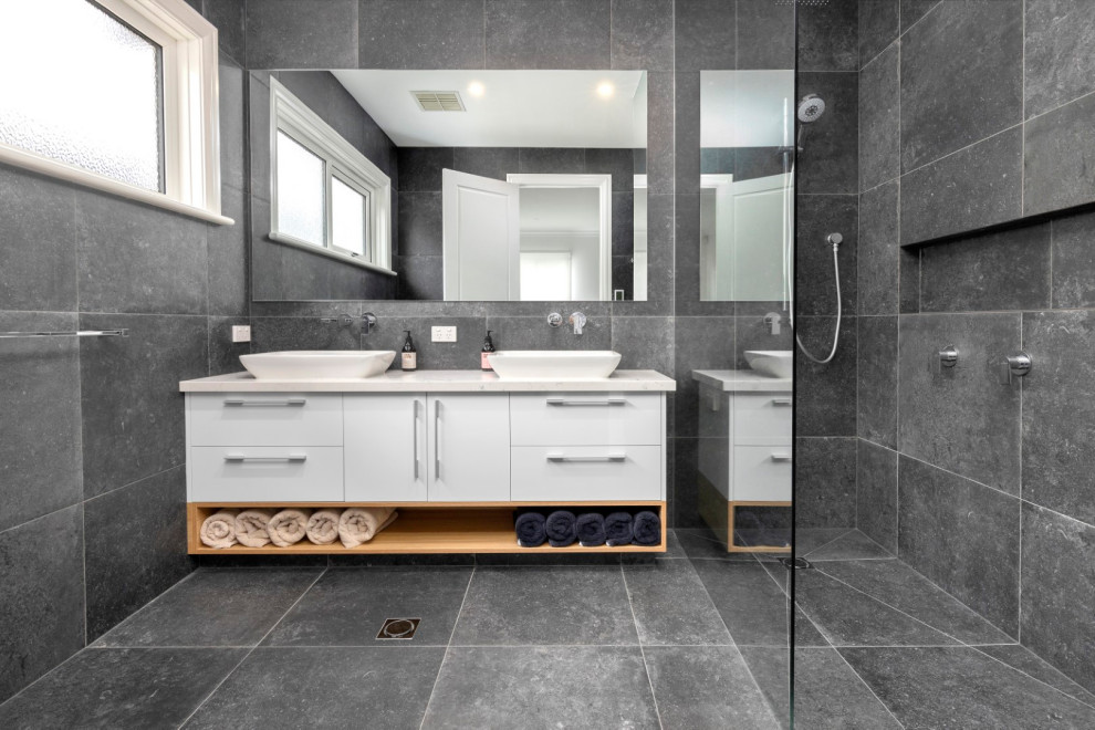 Photo of a large modern kids bathroom in Melbourne with flat-panel cabinets, white cabinets, an open shower, gray tile, porcelain tile, grey walls, porcelain floors, engineered quartz benchtops, grey floor, an open shower and white benchtops.