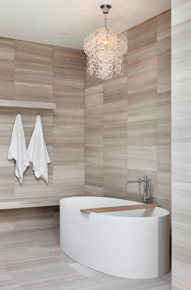 This is an example of a large contemporary master bathroom in Toronto with a freestanding tub, a curbless shower, a one-piece toilet, gray tile, stone tile, grey walls and limestone floors.