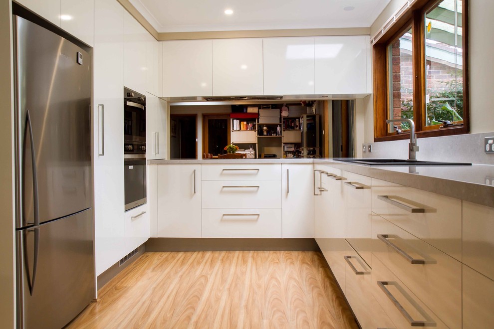 Inspiration for a contemporary u-shaped eat-in kitchen in Melbourne with flat-panel cabinets, white cabinets, quartz benchtops and with island.