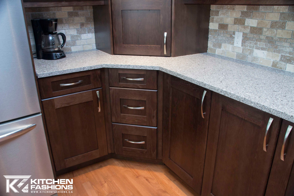 Large transitional u-shaped medium tone wood floor open concept kitchen photo with a farmhouse sink, shaker cabinets, dark wood cabinets, quartz countertops, brown backsplash, stone tile backsplash, stainless steel appliances and an island