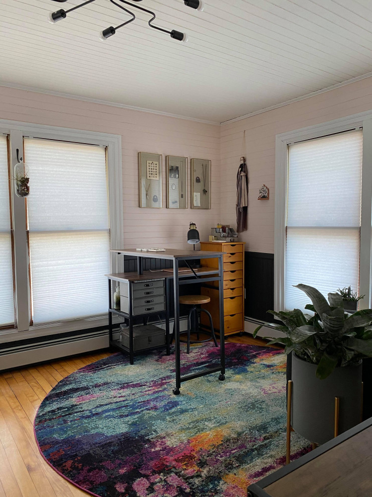 Exempel på ett litet industriellt hemmastudio, med rosa väggar, mellanmörkt trägolv och ett fristående skrivbord
