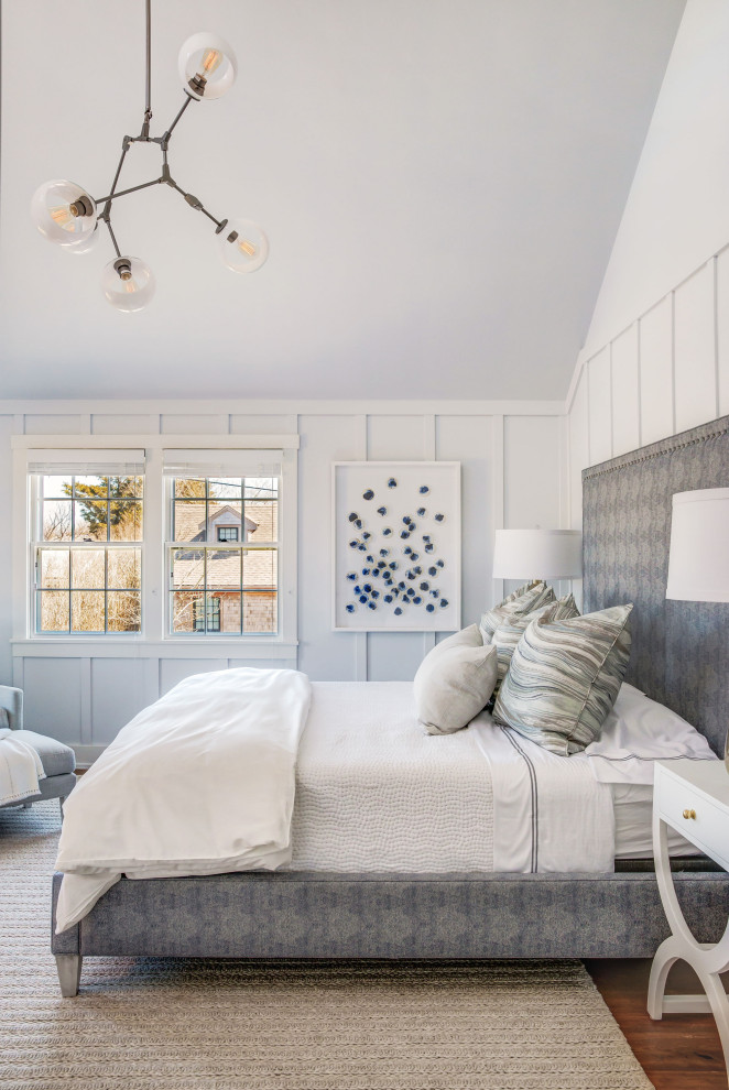 Inspiration for a beach style bedroom in Boston with white walls and brown floor.