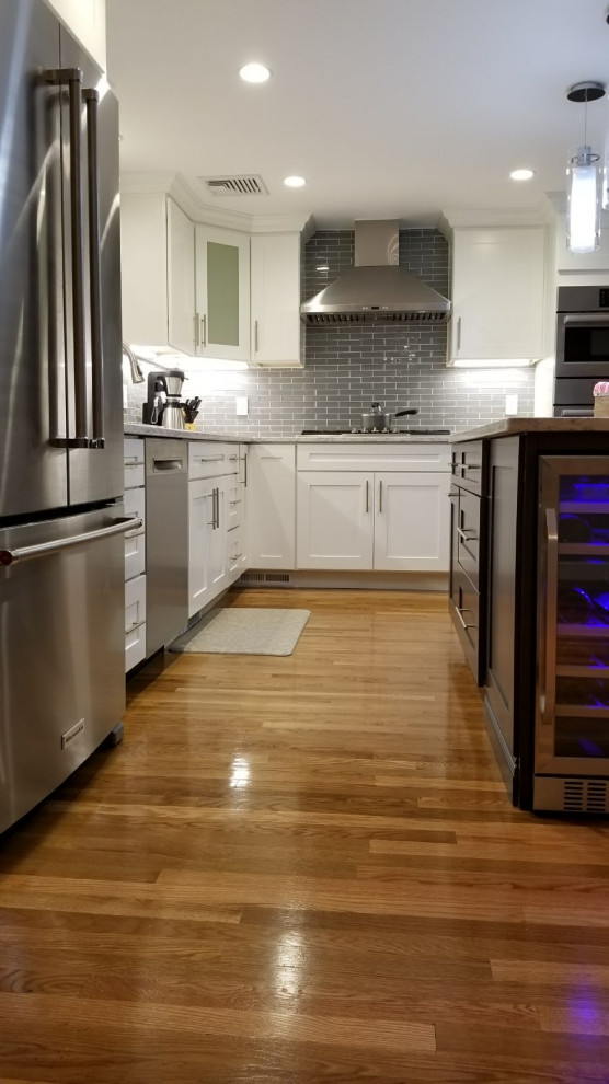Open concept kitchen - mid-sized transitional l-shaped dark wood floor and brown floor open concept kitchen idea with an undermount sink, shaker cabinets, white cabinets, gray backsplash, stainless steel appliances, an island and white countertops
