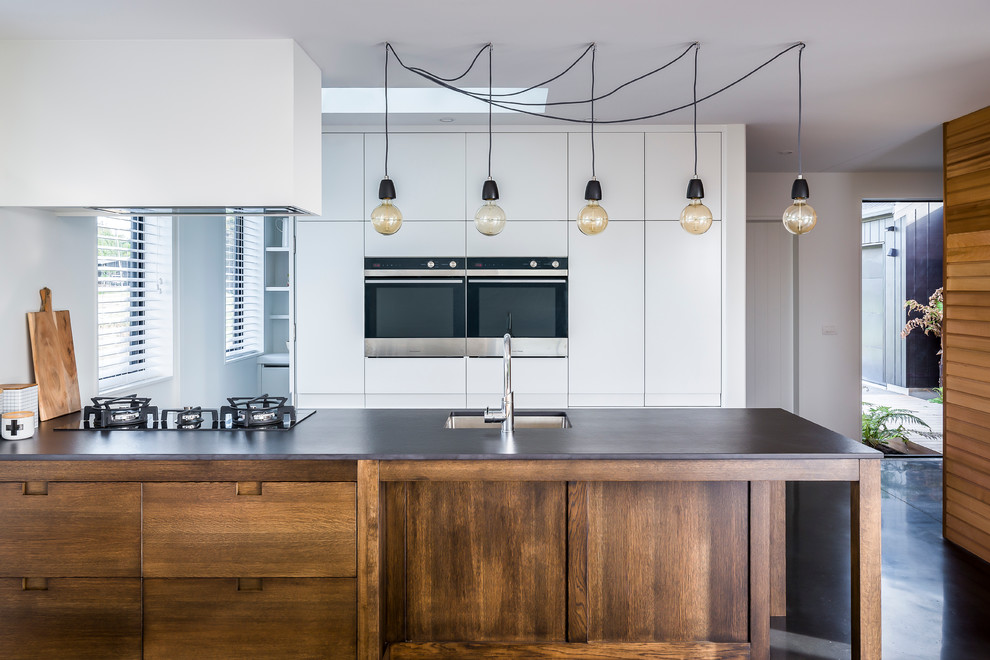 Inspiration for a contemporary kitchen in Wellington with an undermount sink, flat-panel cabinets, white cabinets, stainless steel appliances and a peninsula.