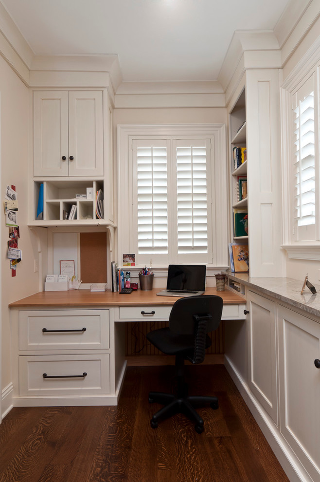 Design ideas for a traditional home office in Other with white walls, dark hardwood floors and a built-in desk.