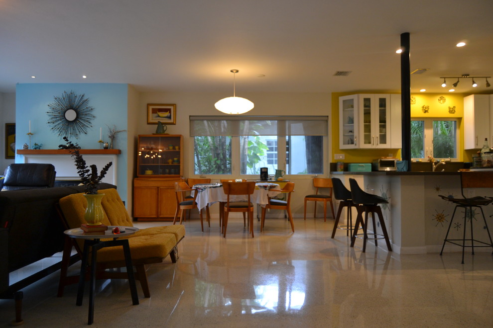 This is an example of a small modern open plan dining in Miami with beige walls and brown floor.