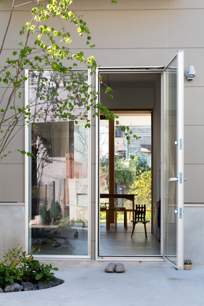 This is an example of a mid-sized modern front door in Tokyo with grey walls, concrete floors, a single front door, a metal front door, white floor, timber and planked wall panelling.