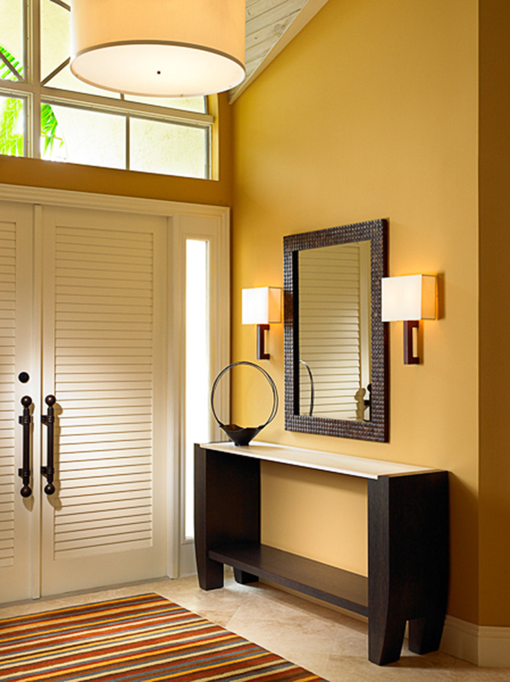 Photo of a large asian foyer in Miami with yellow walls, a double front door, a white front door and limestone floors.