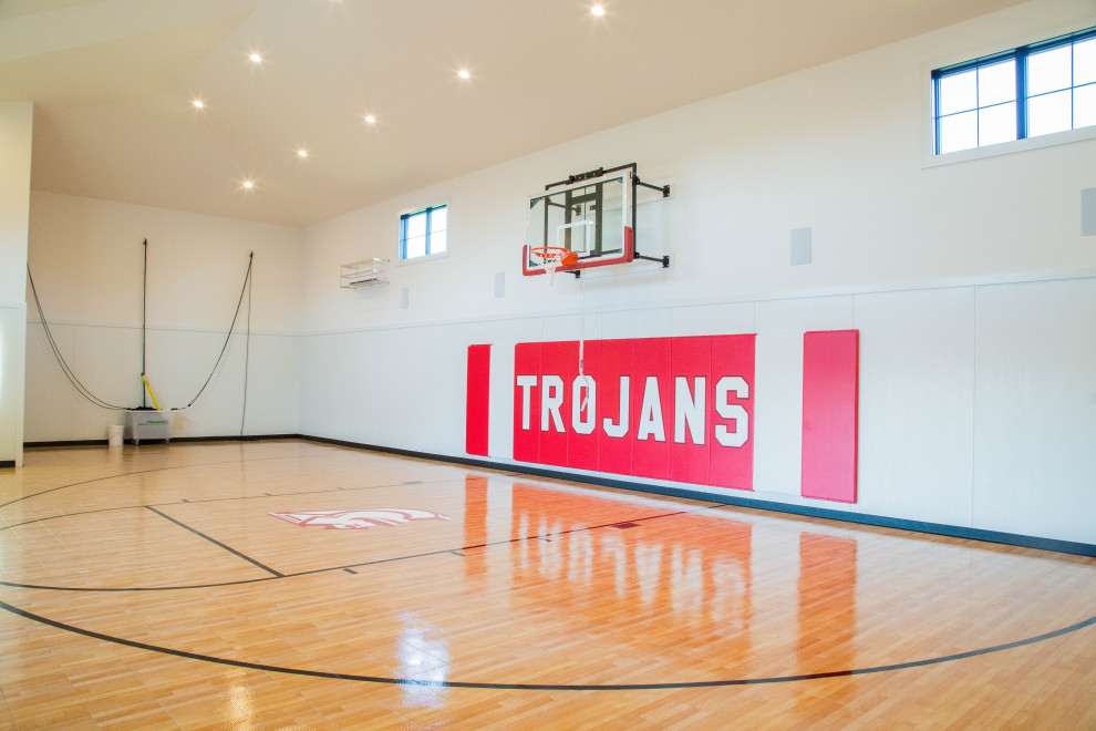 Design ideas for an expansive modern indoor sports court in Indianapolis with beige walls and brown floors.