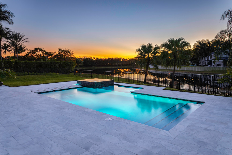 Design ideas for a mid-sized modern backyard rectangular lap pool in Miami with a hot tub.