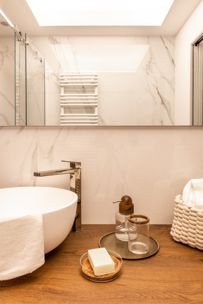 Idéer för ett mellanstort eklektiskt vit badrum med dusch, med släta luckor, skåp i mörkt trä, en kantlös dusch, en vägghängd toalettstol, vit kakel, marmorkakel, vita väggar, marmorgolv, ett fristående handfat, träbänkskiva, vitt golv och dusch med skjutdörr