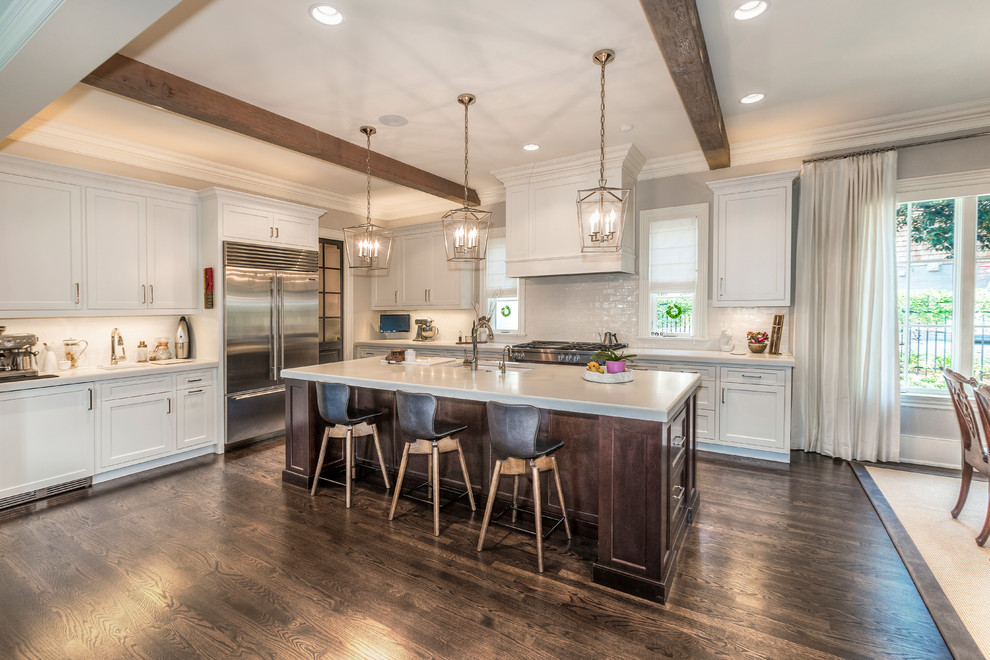 Eat-in kitchen - large transitional l-shaped dark wood floor and brown floor eat-in kitchen idea with an undermount sink, shaker cabinets, white cabinets, quartz countertops, white backsplash, subway tile backsplash, stainless steel appliances, an island and white countertops