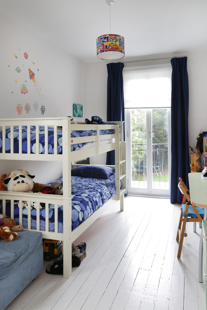 Design ideas for a transitional kids' bedroom for kids 4-10 years old and boys in London with white walls, painted wood floors and white floor.