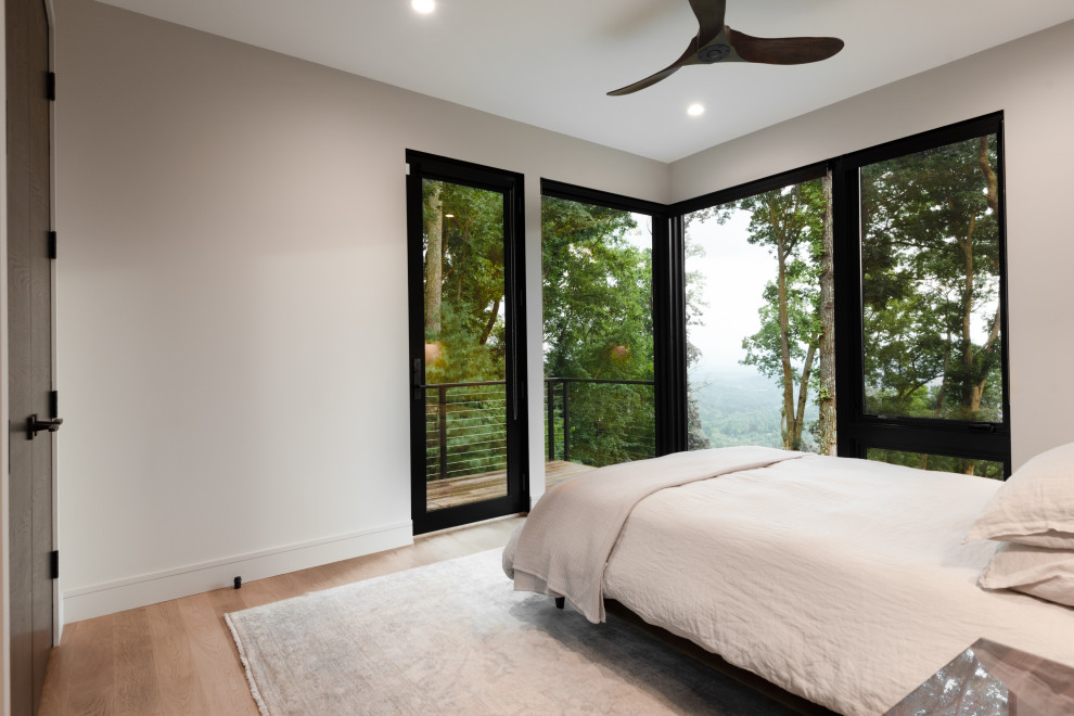 Inspiration för ett minimalistiskt gästrum, med vita väggar och ljust trägolv