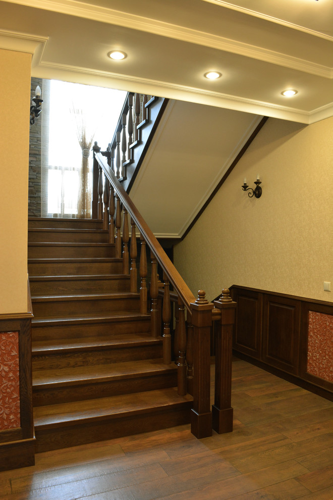 Photo of a mid-sized traditional wood u-shaped staircase in Other with wood risers.