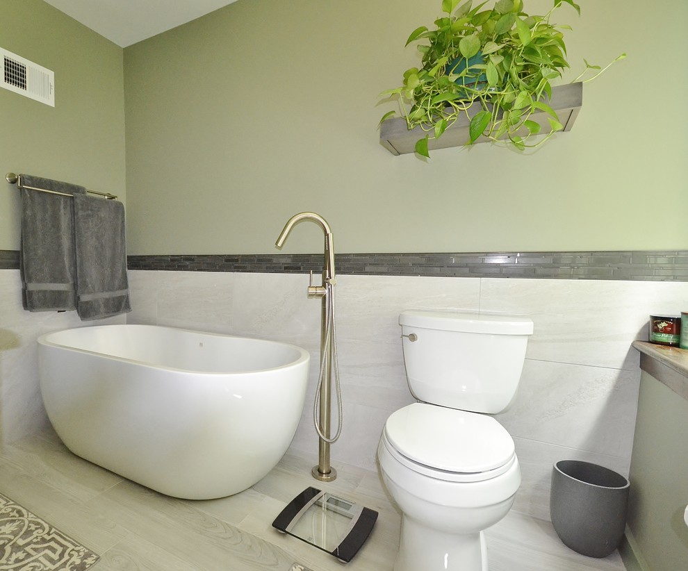 Mid-sized transitional master bathroom in Philadelphia with flat-panel cabinets, beige cabinets, a freestanding tub, a corner shower, a one-piece toilet, white tile, ceramic tile, green walls, ceramic floors, an undermount sink, granite benchtops, beige floor, a hinged shower door and multi-coloured benchtops.