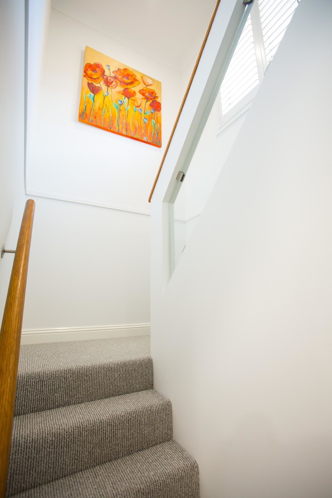 Inspiration for a small modern straight staircase in Brisbane with carpet risers and mixed railing.