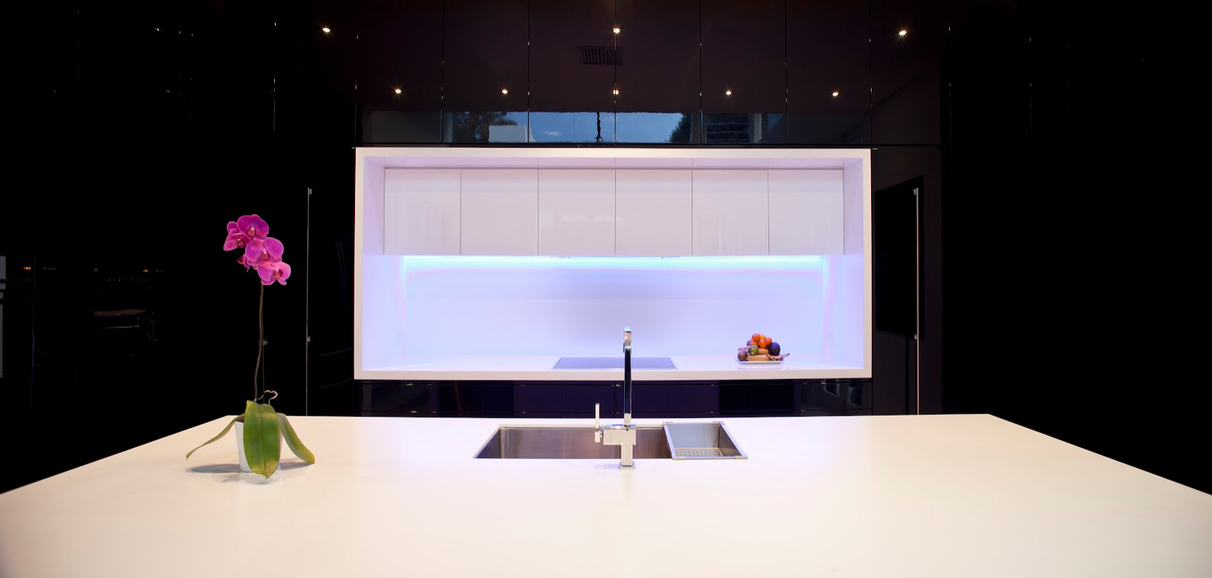High Gloss black kitchen with white corian bench top
