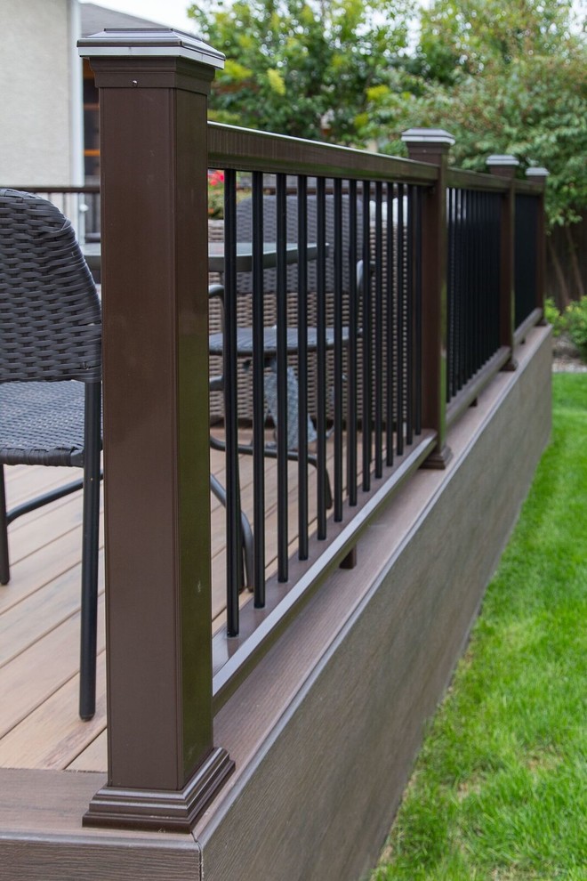 Example of a mid-sized transitional backyard deck design with no cover
