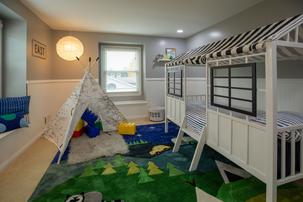 Immagine di una piccola cameretta per bambini da 1 a 3 anni eclettica con pareti grigie, moquette, pavimento beige e boiserie