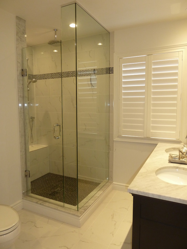 Photo of a mid-sized traditional master bathroom in Toronto with shaker cabinets, dark wood cabinets, a freestanding tub, a corner shower, white walls, an undermount sink, white floor and a hinged shower door.