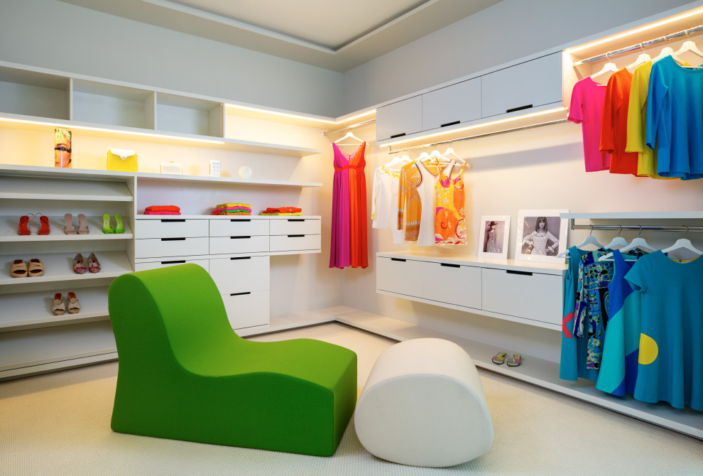Expansive contemporary gender-neutral walk-in wardrobe in Miami with flat-panel cabinets, white cabinets, carpet and beige floor.