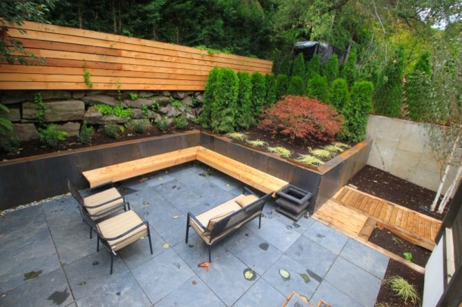 Large asian backyard garden in Seattle with a retaining wall and concrete pavers.