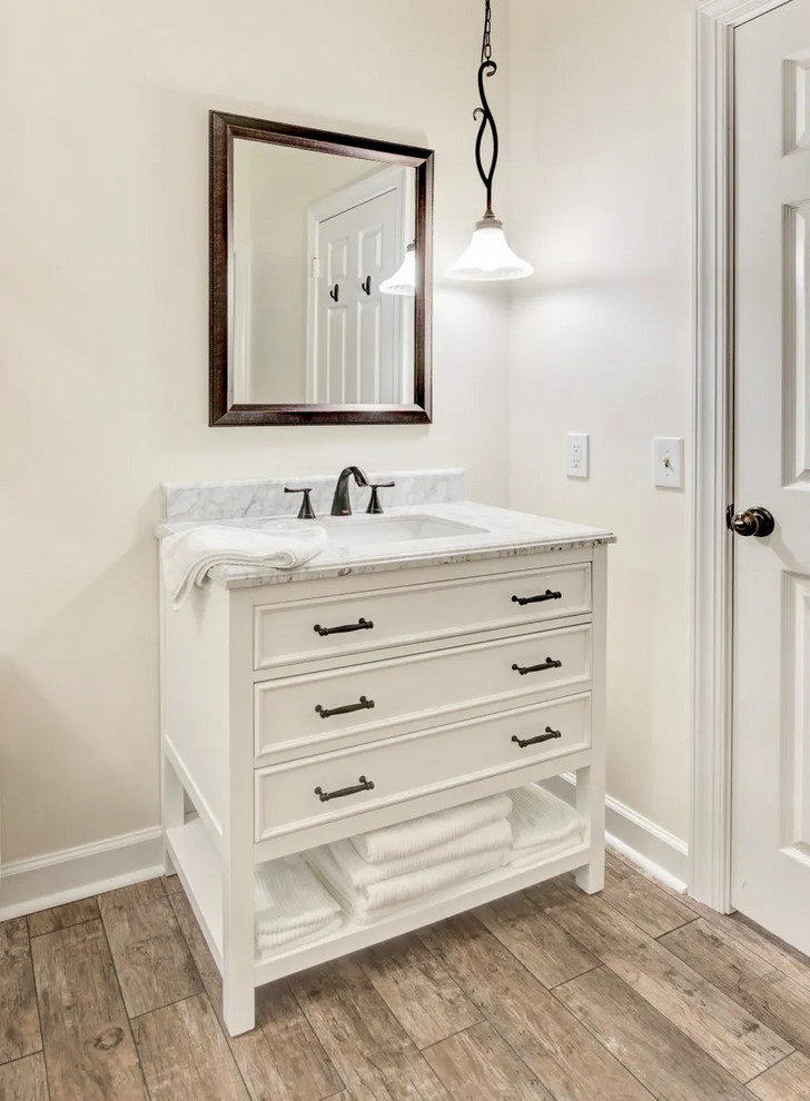 Large contemporary master bathroom in Nashville with open cabinets, white cabinets, a freestanding tub, a shower/bathtub combo, a two-piece toilet, white walls, porcelain floors, an undermount sink, marble benchtops, beige floor, a hinged shower door and white benchtops.