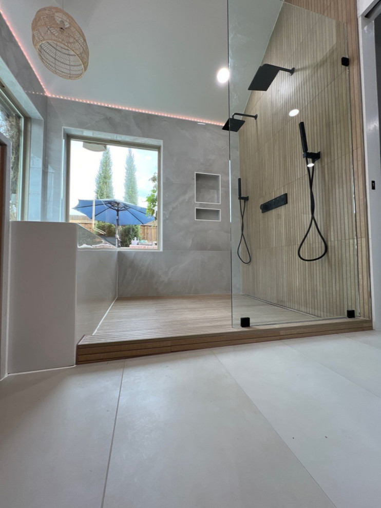 Inredning av ett modernt en-suite badrum, med ett fristående badkar, en dusch/badkar-kombination, klinkergolv i keramik och med dusch som är öppen