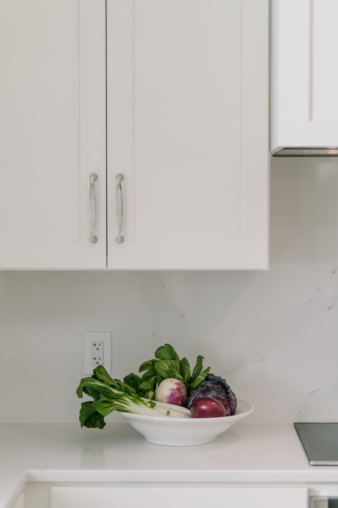 Eat-in kitchen - large transitional l-shaped laminate floor and brown floor eat-in kitchen idea with an undermount sink, shaker cabinets, white cabinets, quartz countertops, white backsplash, quartz backsplash, stainless steel appliances, an island and white countertops