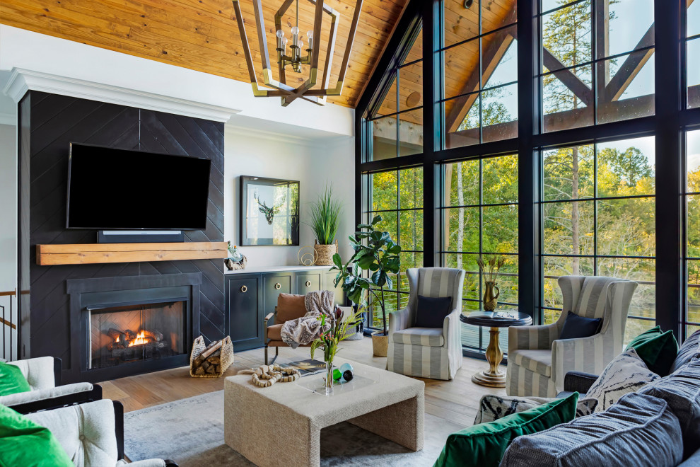 Inspiration for an expansive farmhouse living room in Raleigh with white walls, medium hardwood flooring, a standard fireplace, a wall mounted tv, brown floors, a vaulted ceiling and a wood ceiling.