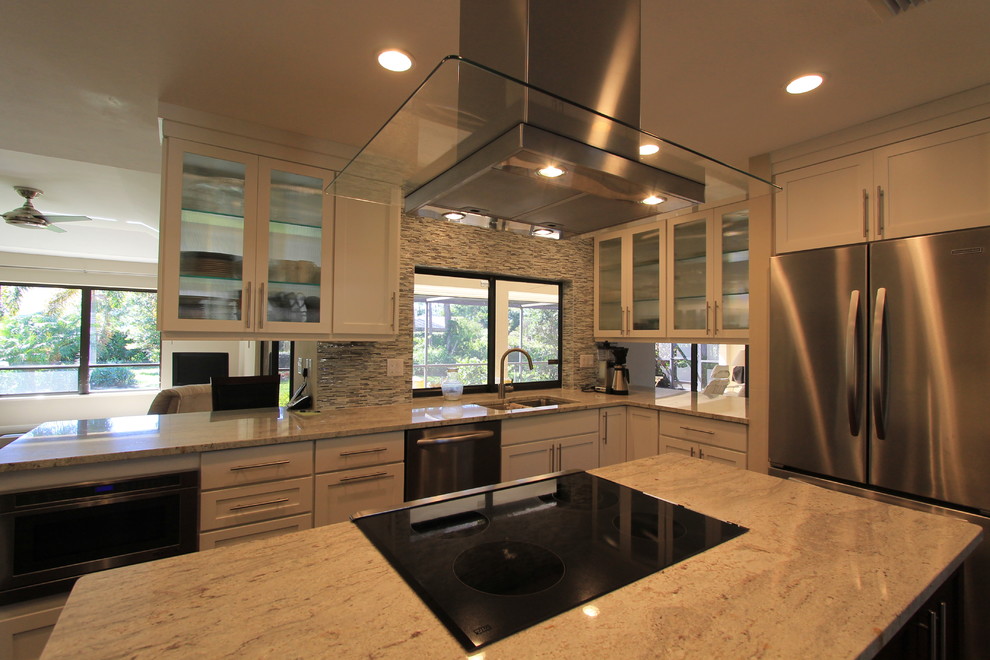 Eat-in kitchen - large transitional l-shaped medium tone wood floor eat-in kitchen idea in Miami with an undermount sink, shaker cabinets, white cabinets, granite countertops, multicolored backsplash, matchstick tile backsplash, stainless steel appliances and an island