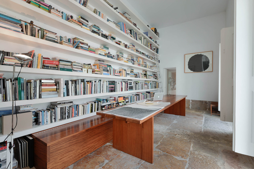 Mid-sized mediterranean study room in New York with beige walls, limestone floors, no fireplace and a freestanding desk.