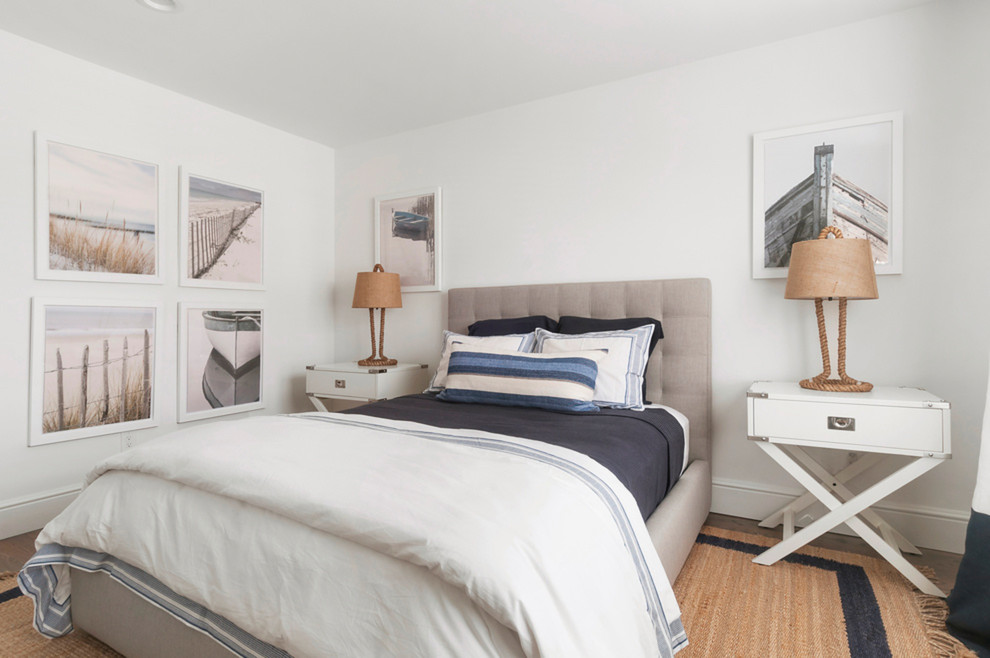 Beach style bedroom in New York with white walls, dark hardwood floors and brown floor.