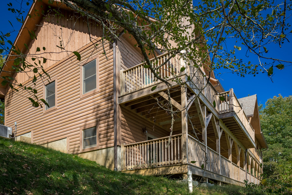 Deck - huge rustic backyard deck idea in Charlotte with a roof extension