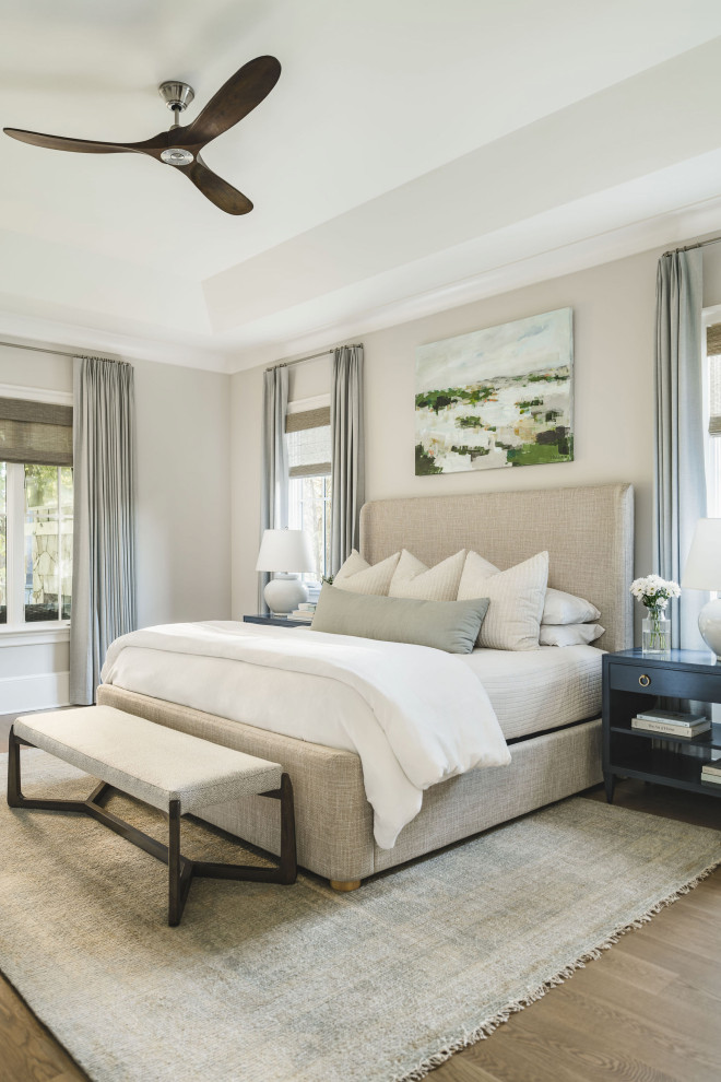 Foto de dormitorio principal clásico renovado grande con paredes beige, suelo de madera en tonos medios y bandeja