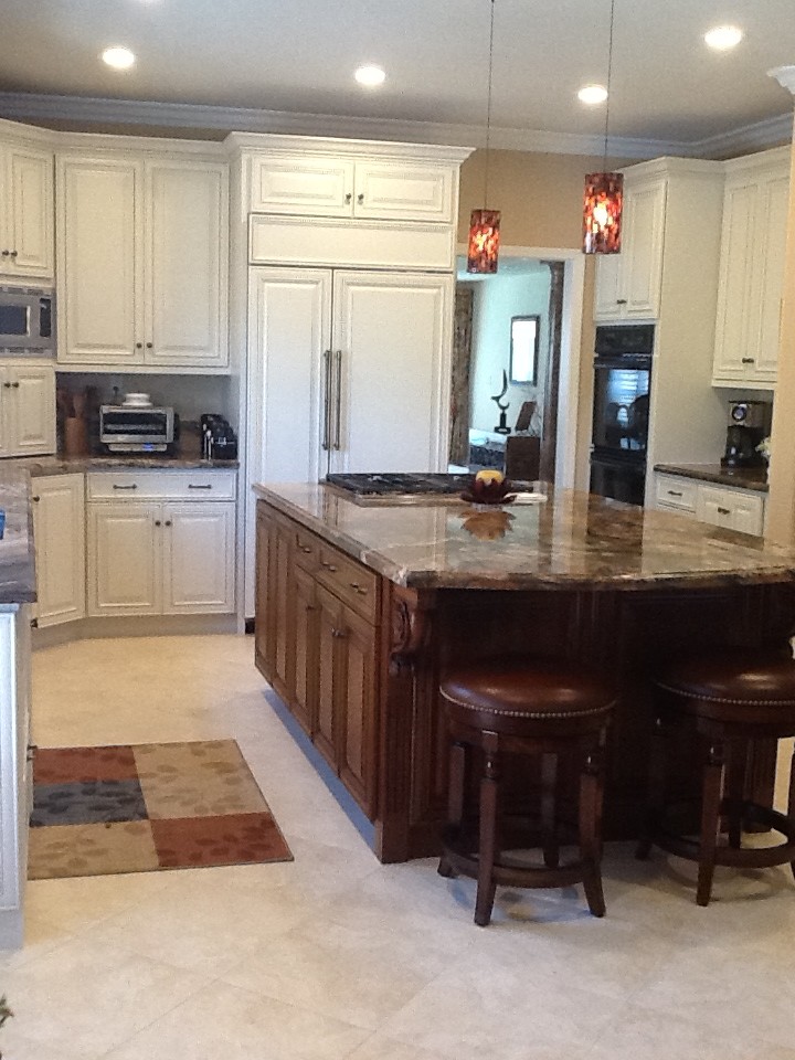 Photo of a large traditional u-shaped eat-in kitchen in San Francisco with an undermount sink, raised-panel cabinets, white cabinets, granite benchtops, panelled appliances, porcelain floors, with island, multi-coloured splashback and glass tile splashback.
