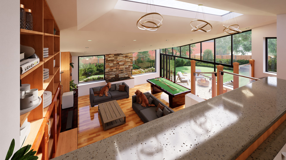 This is an example of a medium sized contemporary mezzanine living room with a reading nook, medium hardwood flooring, a ribbon fireplace, a stacked stone fireplace surround, a built-in media unit, a vaulted ceiling and a chimney breast.